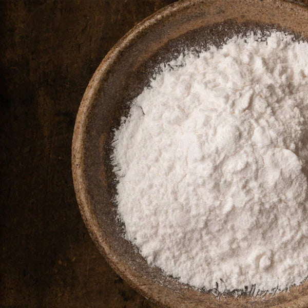 White powder in a brown bowl on a dark background