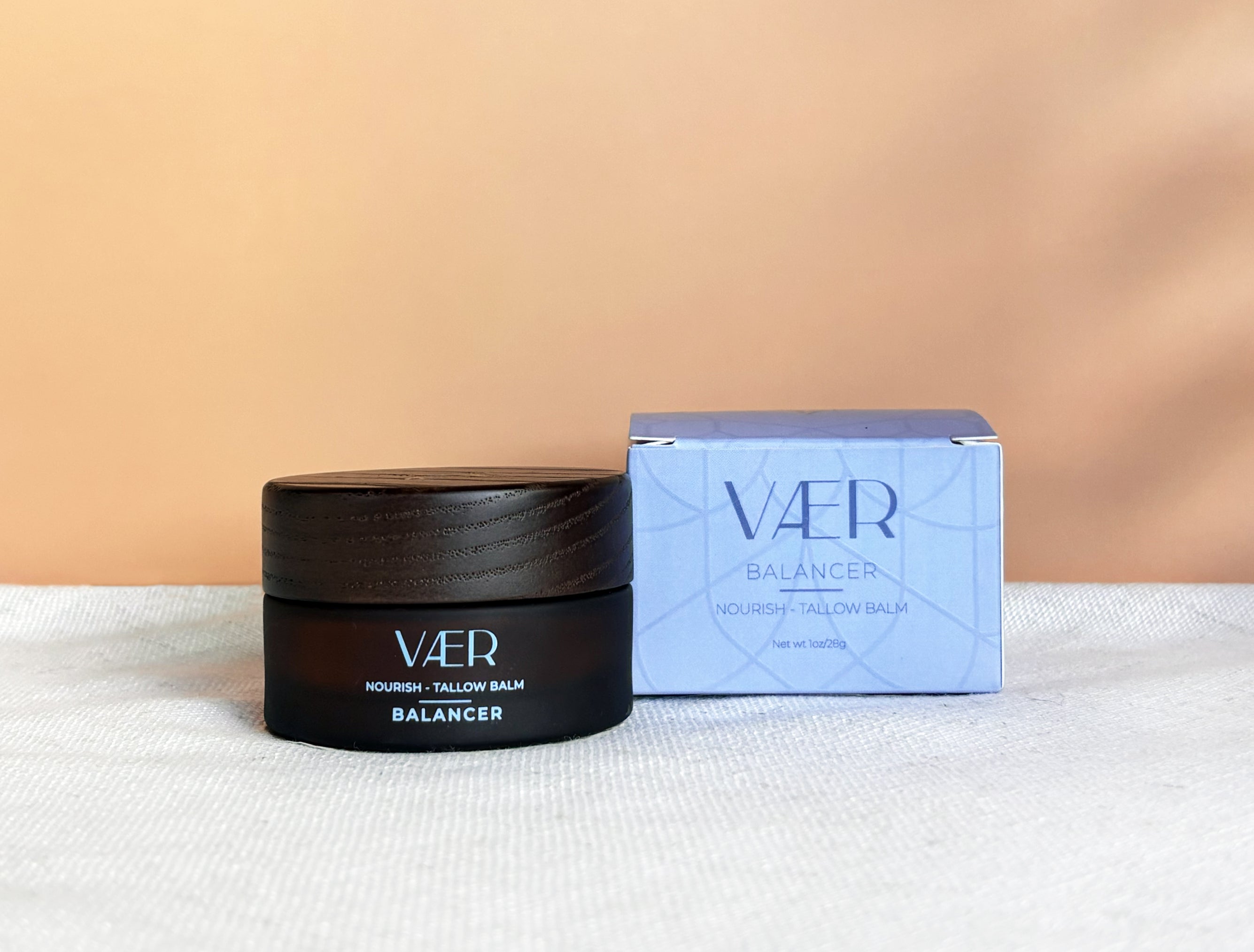 Vaer balm jar and box on a white surface with a beige background